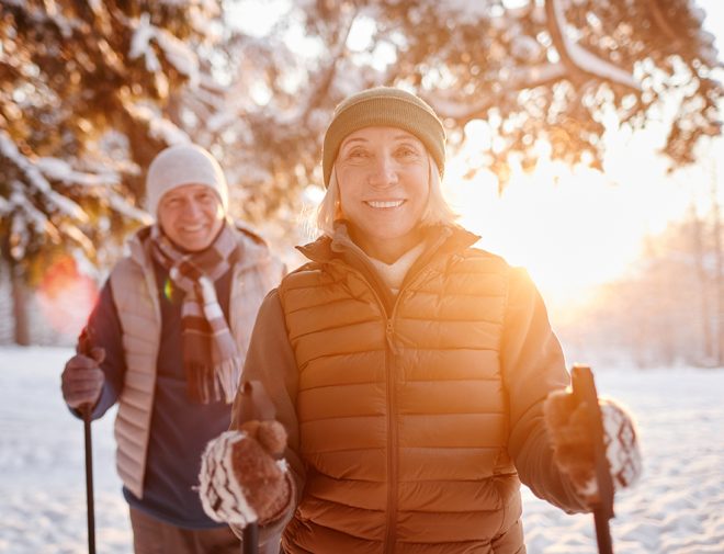 An older woman and a man hiking in the snow