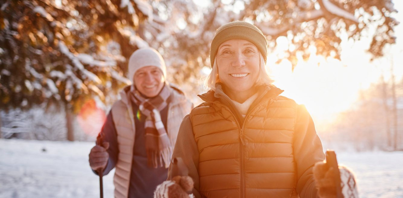 An older woman and a man hiking in the snow