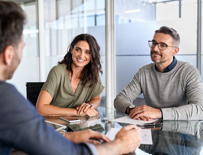 A man and a woman sitting at a table and smiling at the person across from them