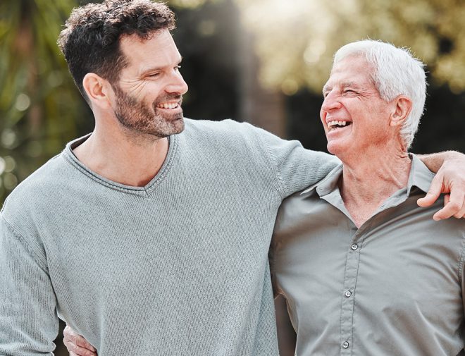 A middle-aged man hugging an older man