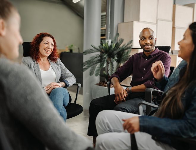 A group of people sitting in chairs in a circle