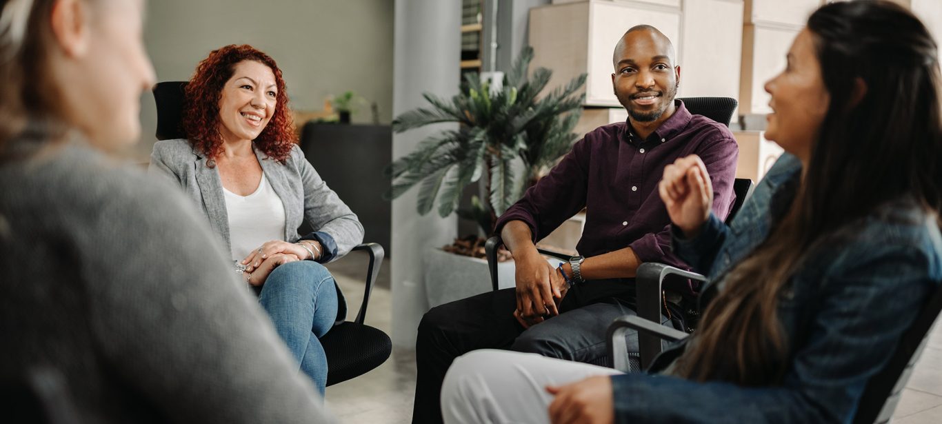 A group of people sitting in chairs in a circle