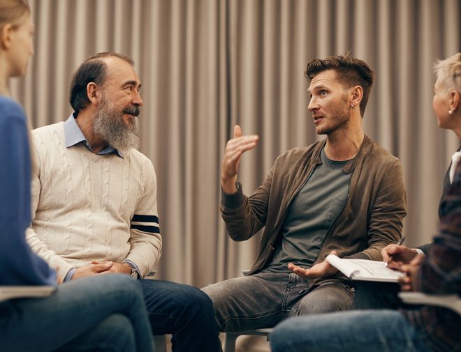 A group of people sitting and talking in a circle