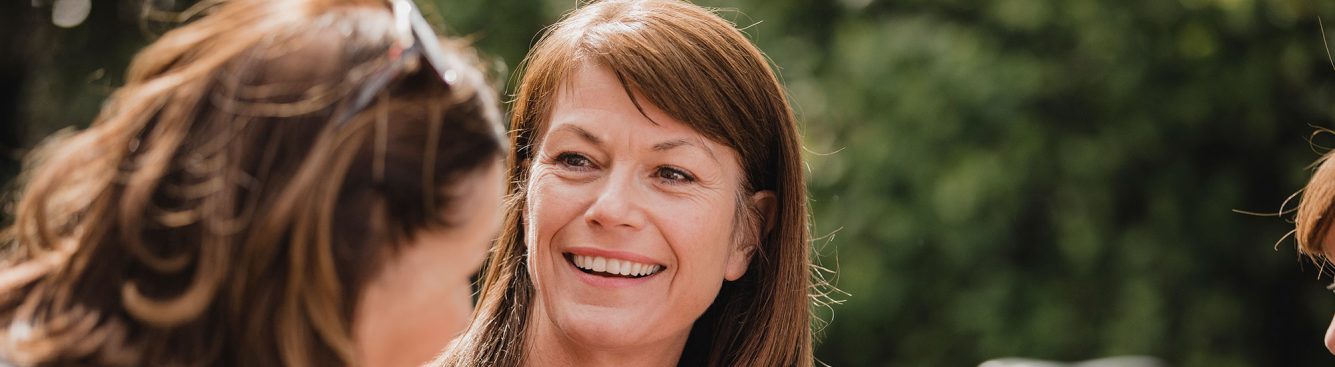 A middle-aged woman smiling at her friend