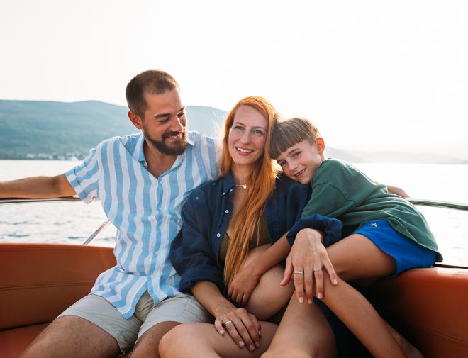 A man, woman, and child sitting on a boat and smiling