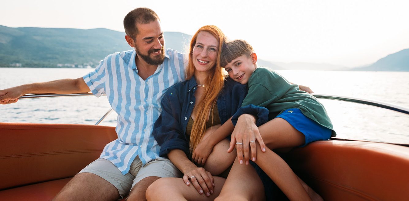 A man, woman, and child sitting on a boat and smiling