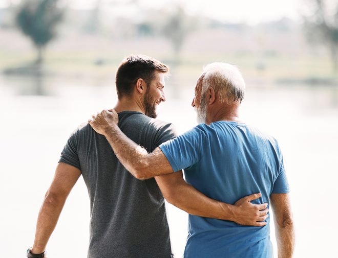 A young man hugging an older man